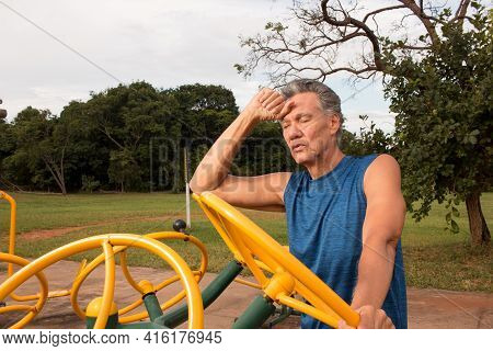 Senior Man Working Out At An Outdoor Fitness Park In Parque Das Garças, Brasilia
