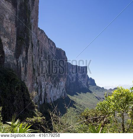 Sheer Cliffs Of Mount Roraima - Landscape With Blue Sky And Clouds Background. View On The Gran Saba