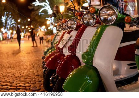 Scooter Rental On Nigth Street. Multicolored Scooters On Tourist Street. Parking Rental Vehicle. Sel