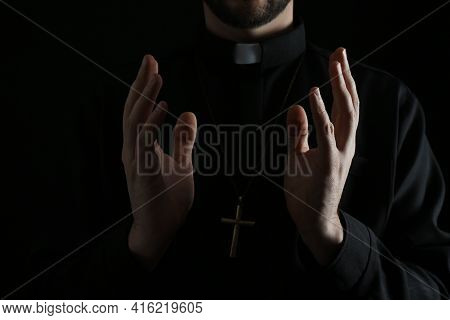Priest In Cassock Praying On Dark Background, Closeup