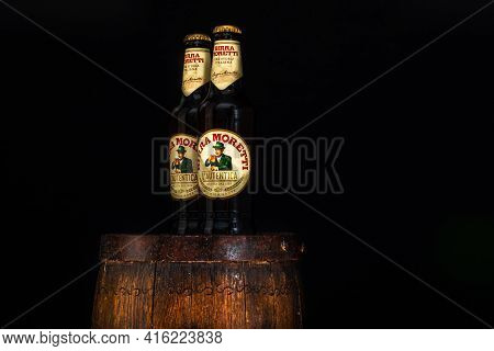 Bottle Of Birra Moretti Beer On Wooden Barrel With Dark Background. Illustrative Editorial Photo Buc