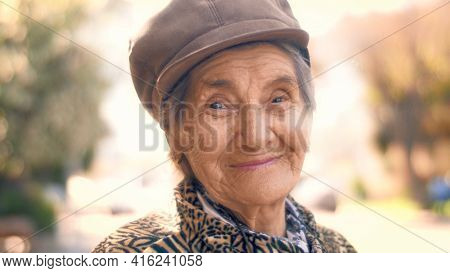 Portrait of happy smiling 92 year old senior woman outdoors. Closeup, shallow DOF.