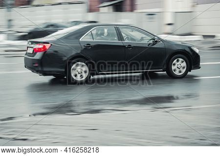 Moscow, Russia - January 2021: Fast Moving Black Toyota Camry Xv50 Rides On A Winter City Road. A Ca