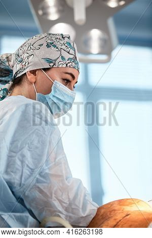 Cosmetic Liposuction Surgery In Actual Operating Room Setting Showing Surgeon Hands And Cannula.