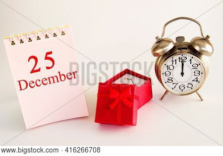 Calendar Date On Light Background With Red Gift Box With Ring And Alarm Clock With Copy Space. Decem