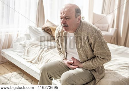 Elderly Man With Bellyache Holding Stomach With His Hand