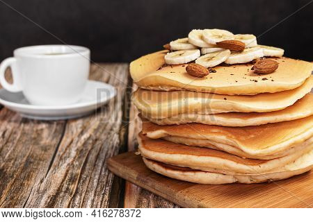Fritters On A Wooden Board With A Cup Of Coffee On A Dark Background In A Close-up