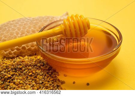 A Ladle Of Honey On The Background Of A Honeycomb Of A Bee. Honey Tidbit In A Glass Jar Honey Spoon,