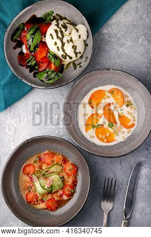 Various Salad Top View. Ceviche, Buratta And Persimmon With Pine Nuts. Different Fresh Salads