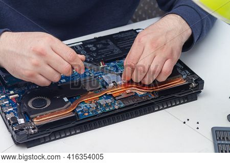 An Office Equipment Repairman Disassembles A Laptop To Find A Fault.