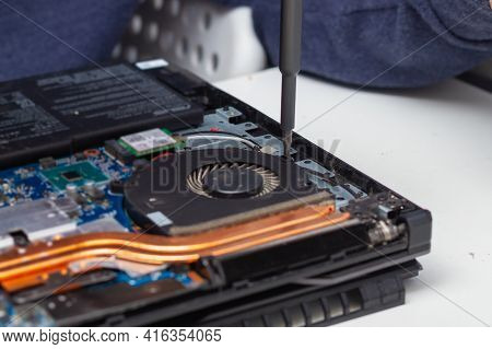 An Office Equipment Repairman Disassembles A Laptop To Find A Fault.