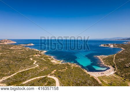 A Boat Sits In A Bay On The Turquoise Mediterranean Sea At Plage De L'alga At La Revellata Near Calv