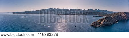 Panoramic Aerial View Of Boat Passing Revellata Lighthouse On A Rocky Promontory With The Citadel Of