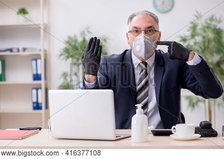 Old male boss employee working during pandemic