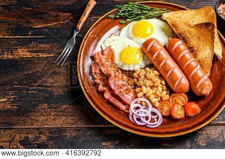 Traditional Full English Breakfastt With Fried Eggs, Sausages, Bacon, Beans And Toasts. Dark Wooden 