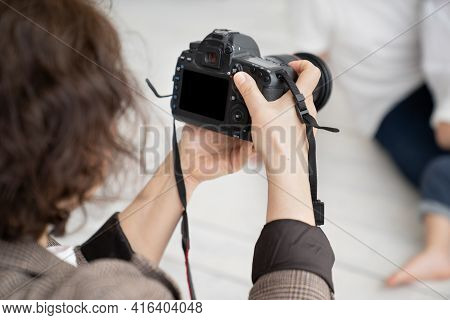 A Brunette Woman Working Photographer. Photo Shoot In A Photo Studio. Backstage