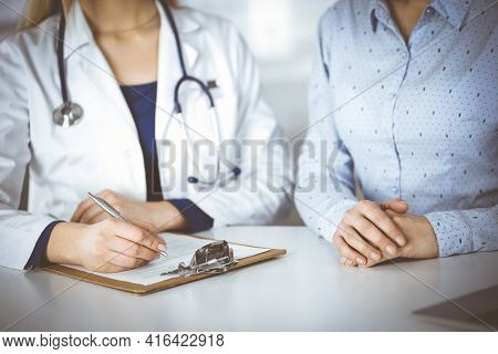 Unknown Woman- Doctor And Her Patient Are Discussing Patients Blood Test, While Sitting Together At 