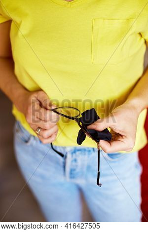 Close Up Crop Hands Of Woman Wiping Trendy Black Glasses Lens With Towel, Black Microfiber Tissue