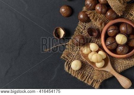 Dry Roasted Macadamia Nut In Wood Spoon And On Black Background, Macadamia Nuts Are Loaded With Flav