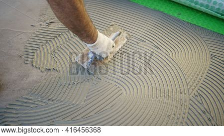 Worker Applies Waterproofing With A Small Brush