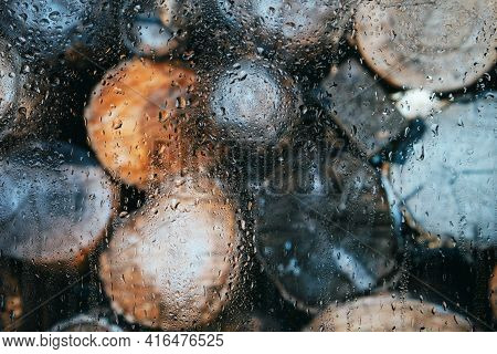 Glass After Rain In Drops On A Blurred Background Of Logs, Roundwood.