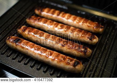 Grilled Meat Sausages For Hot Dog, Kupaty, Fatty Food Cooked On The Barbecue, With Fresh Vegetables 