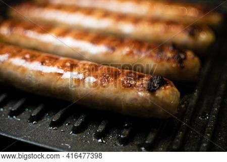 Grilled Meat Sausages For Hot Dog, Kupaty, Fatty Food Cooked On The Barbecue, With Fresh Vegetables 