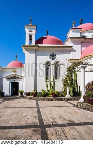 Place of worship and pilgrimage. The Monastery of the Holy Twelve Apostles. Israel. Capernaum. Snow-white church with pink domes. The concept of religious pilgrimage, educational and photo tourism
