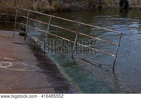 Old Rusty Sunken Pier In The Water On The Territory Of The River Port. Old Sunken Rusty Structure On