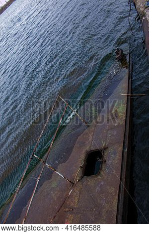 Old Rusty Sunken Pier In The Water On The Territory Of The River Port. Old Sunken Rusty Structure On
