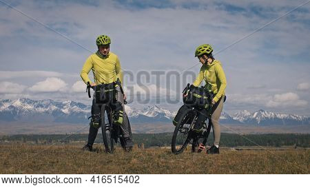The Man And Woman Travel On Mixed Terrain Cycle Touring With Bikepacking. The Love Couple Journey Wi