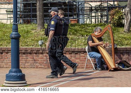 Frederick, Md, Usa 04-07-2021: An Elderly Caucasian Busker Is Playing Harp On The Street In Carroll 