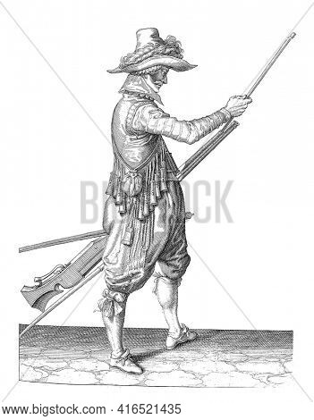 A soldier, ten feet, to the right, holding a musket (a particular type of firearm) with his left thigh and sliding the ramrod into the barrel under the barrel with his right hand, vintage engraving.