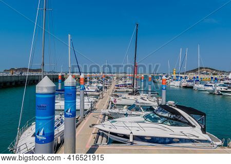 Pyeongtaek, South Korea; April 6, 2021: Yachts Moored At Jeongok Port Marina With Red Lighthouse In 