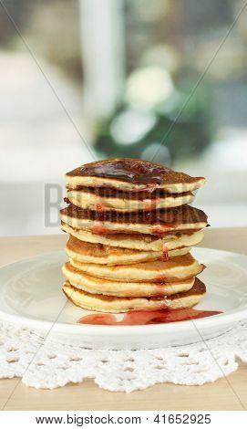 หวาน pancakes บนแผ่นกับแยมบนโต๊ะในห้องครัว