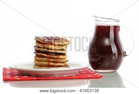 หวาน pancakes บนแผ่นกับนมข้นที่แยกต่างหากบนพื้นสีขาว