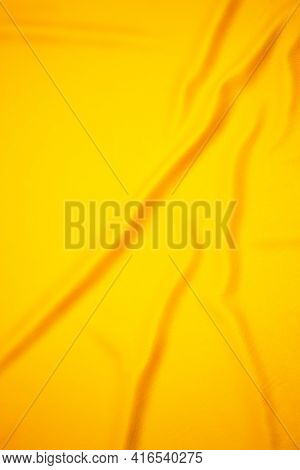 Yellow Background In The Form Of Crumpled Fabric. Surface In Folds In The Shape Of Waves
