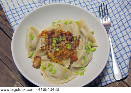 Fried Dumplings Stuffed With Cabbage And Meat Sprinkled With Bacon Greaves And Chopped Parsley On A