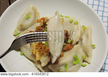Fried Dumplings Stuffed With Cabbage And Meat Sprinkled With Bacon Greaves And Chopped Parsley On A