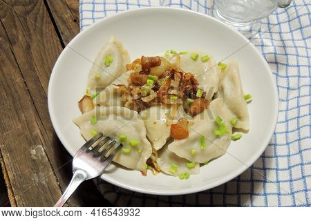 Fried Dumplings Stuffed With Cabbage And Meat Sprinkled With Bacon Greaves And Chopped Parsley On A