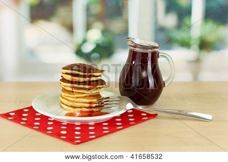 หวาน pancakes บนแผ่นกับแยมบนโต๊ะในห้องครัว