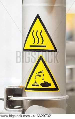 Stainless Steel Flange Of A Chemical Vessel Assembly With Warnings For Heat And Corrosive Danger