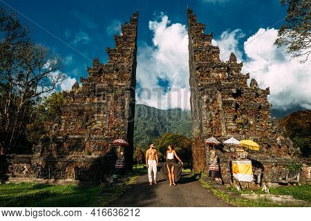 Traveling Couple In Bali. Happy Couple Vacationing In Asian Countries. Couple At The Bali Gate. A Ma