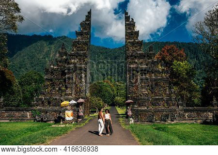 Traveling Couple In Bali. Happy Couple Vacationing In Asian Countries. Couple At The Bali Gate. A Ma