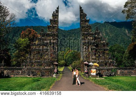 Traveling Couple In Bali. Happy Couple Vacationing In Asian Countries. Couple At The Bali Gate. A Ma