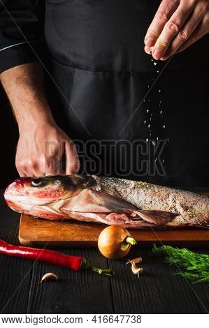 The Chef Prepares Fresh Fish Bighead Carp Sprinkling Salt With The Ingredients. Preparing To Cook Fi