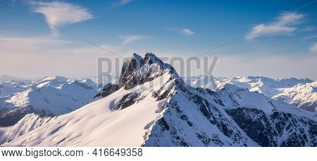 Aerial View From Airplane Of Blue Snow Covered Canadian Mountain Landscape In Winter. Bright Sunny B