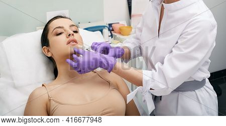 Beautician Doing Filler Injection In Female Lips For Womans Lip Augmentation. Injections For Increas