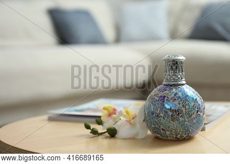 Stylish Catalytic Lamp With Orchid On Wooden Table In Living Room, Space For Text. Cozy Interior