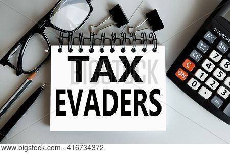 Tax Evaders. Text On White Paper On Gray Background
